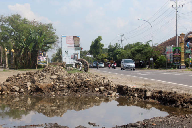 Kubangan jalan menganga di pinggir jalan Sragen-Solo, Desa Krikilan, Kecamatan Masaran, Sragen, Minggu (13/6/2021). (Solopos/Tri Rahayu)