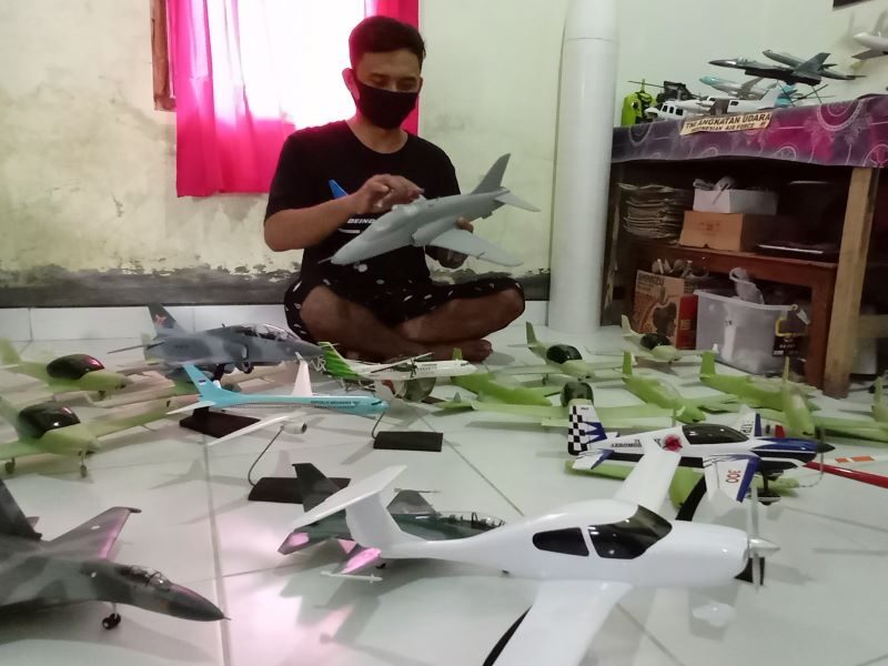 Warga Desa Kismoyoso, Kecamatan Ngemplak, Kabupaten Boyolali, Deni Kurniawan, 31, Senin (31/5/2021), menyelesaikan pembuatan miniatur pesawat terbang di rumahnya. (Solopos.com/Bayu Jatmiko Adi)