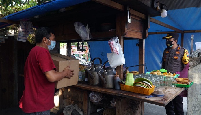 Kapolres Grobogan AKBP Benny Setyowadi menyerahkan bantuan kepada pedagang angkringan di Jajar, Kelurahan/Kecamatan Purwodadi, Jumat (16/7/2021). (Solopos.com-Polres Grobogan)