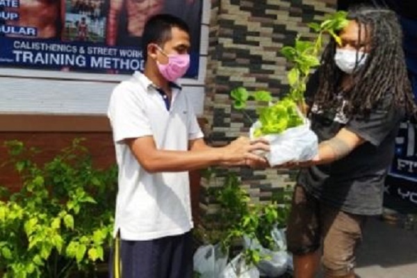 Inisiator aksi Berbagi Bahagia di Masa Pandemi, Erick Setya Darmawan (kanan), membagikan bibit sayuran kepada warga di Kota Salatiga, Minggu (18/7/2021). (Semarangpos.com-Imam Yuda S.)