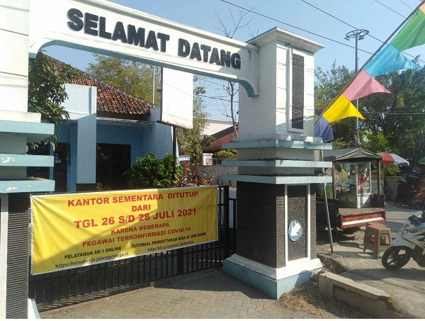 Pengumuman Kantor Disnakertrans Grobogan ditutup sementara karena ada pegawai positif Covid-19 di pasang di pintu masuk kantor, Senin (26/7/2021). (Solopos.com/Arif Fajar S.)