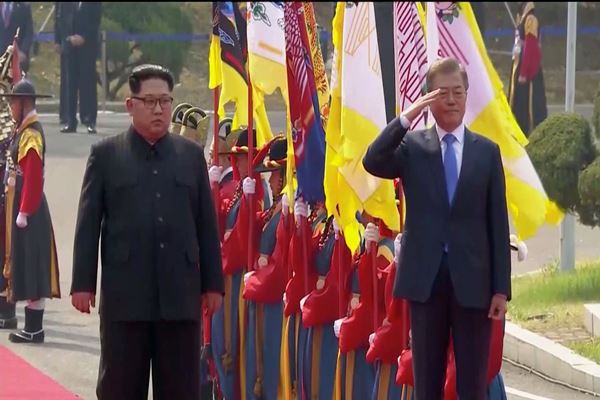 Presiden Korea Selatan Moon Jae-in dan pemimpin Korea Utara Kim Jong Un pada upacara penyambutan di KTT antar-Korea di desa gencatan senjata Panmunjom, dalam bingkai ini masih diambil dari video, Korea Selatan pada tanggal 27 April 2018. (Bisnis-Reuters)