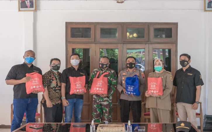 Pendiri Dua Naga Corps, Luki Adhi Sulaksono (ketiga dari kiri) bersama unsur forum komunikasi pimpinan kecamatan (Forkopimcam) Gatak mengangkat tas paket sembako yang disalurkan kepada warga terdampak pandemi Covid-19 di Pendapa Kantor Camat Gatak, Selasa (27/7/2021).(Bony Eko Wicaksono/Solopos)