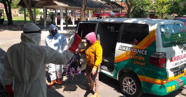 Petugas ber-APD mengarahkan warga terpapar Covid-19 masuk ke GOR Gelarsena Klaten, Sabtu (24/7/2021). (Solopos-Ponco Suseno)