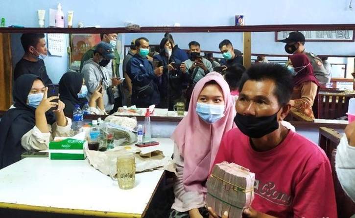 Mang Eman, pedagang agar-agar, menunjukkan uang hasil donasi senilai Rp108 juta. (detik.com)