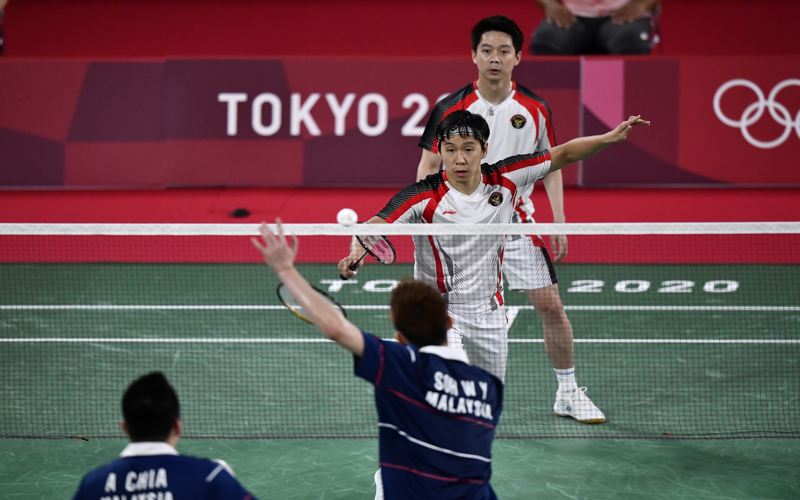 Pebulu tangkis ganda putra Indonesia Marcus Fernaldi Gideon/Kevin Sanjaya Sukamuljo mengembalikan kok ke arah ganda putra Malaysia Aaron Chia/Wooi Yik Soh dalam perempat final Olimpiade Tokyo 2020 di Musashino Forest Sport Plaza, Tokyo, Jepang, Kamis (29/7/2021). (ANTARA FOTO/Sigid Kurniawan/aww)