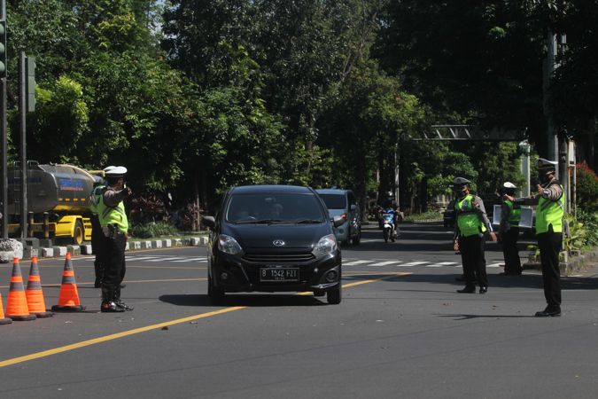 Polisi melakukan penyekatan kendaraan berpelat nomor luar Kota Solo di Pos Simpang Faroka, Jl Slamet Riyadi, Solo, Minggu (4/7/2021). (Solopos/Nicolous Irawan)