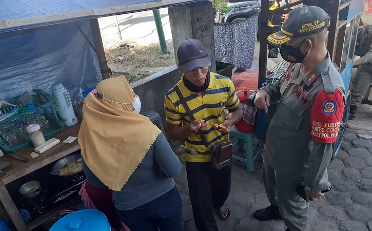 Kepala Satuan Polisi Pamong Praja (Satpol PP) Sukoharjo, Heru Indarjo (kanan) memperingatkan pedagang kaki lima (PKL) agar tidak melayani makan di tempat selama penerapan pemberlakuan pembatasan kegiatan masyarakat (PPKM) darurat di sekitar Terminal Sukoharjo, Selasa (6/7/2021). (Solopos/Bony Eko Wicaksono)