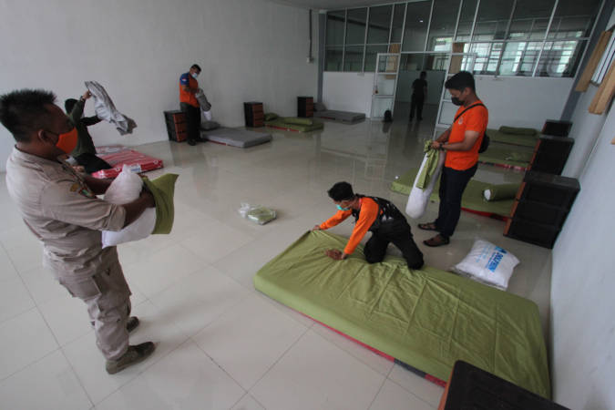 Petugas BPBD Kota Solo menata tempat tidur di salah satu ruang untuk isolasi pasien positif Covid-19 OTG di Solo Technopark (STP), Solo, Selasa (29/6/2021). (Solopos/Nicolous Irawan)