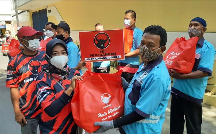 Pengurus PAC PDIP Jebres menyerahkan bantuan paket sembako kepada petugas parkir di Jl. Urip Sumoharjo Solo, Sabtu (24/7/2021) siang. (Solopos-Kurniawan)