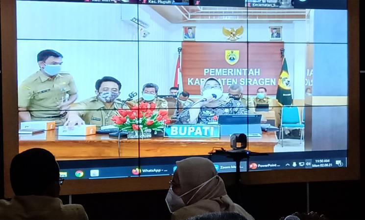 Dua orang pejabat berdiskusi tentang penanganan Covid-19 di sela-sela pelaksanaan Zoom Meeting antara Bupati dengan tiga kecamatan di Sragen Command Center (SCC), Selasa (2/8/2021). (Solopos/Tri Rahayu)