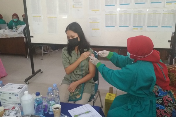 Seorang pelajar SMAN 1 Purwodadi, Grobogan menjalani vaksinasi dosis pertama di sekolah, Kamis (19/8/2021). (Solopos.com/Arif Fajar S)