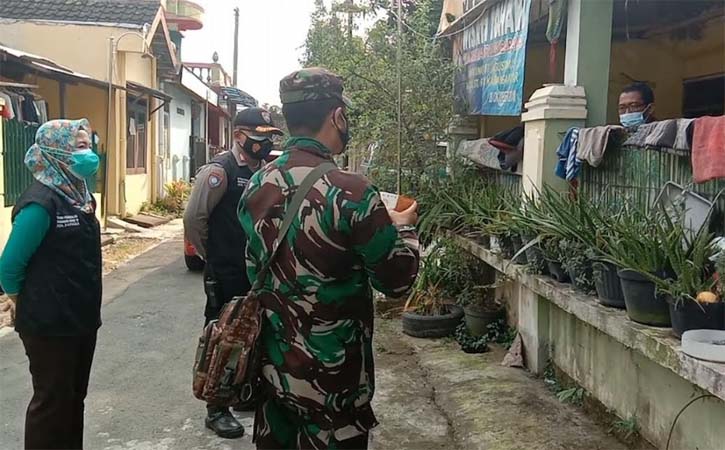 Babinsa, Babhinkamtibmas, dan bidan desa memberikan bantuan obat kepada warga isolasi mandiri di Karanganyar. Foto dirilis Minggu (1/8/2021). (Istimewa-Kodim 0727 Karanganyar)