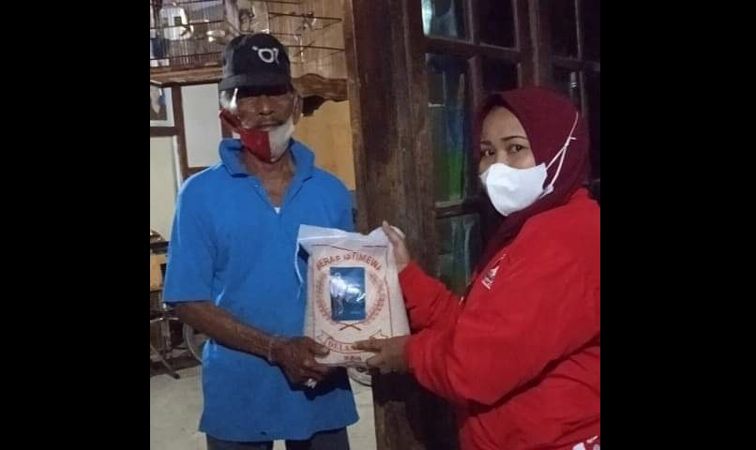 Kader PSI Solo (kanan) menyerahkan bantuan beras dari Wali Kota Solo, Gibran Rakabuming Raka, kepada warga terdampak pandemi Covid-19, belum lama ini. (Istimewa)