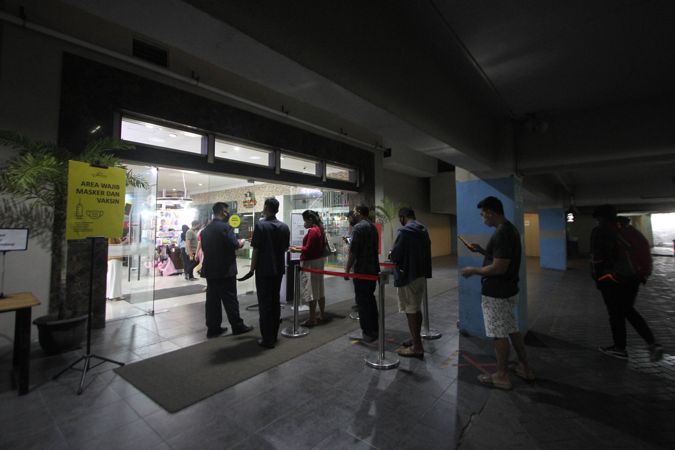Pengunjung antre dengan menjaga jarak aman untuk melakukan scan barcode melalui aplikasi PeduliLindungi saat hendka masuk Solo Paragon Lifestyle Mall, Solo, Minggu (29/8/2021). (Solopos/Nicolous Irawan)