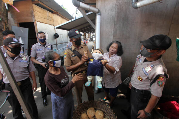 Espos/Nicolous Irawan
Petugas pasar memberikan edukasi kepada pedagang terkait pemakaian masker yang baik dan benar pada ronda masker rutin di Pasar darurat Pasar Legi, Solo, Senin (2/8/2021). Ronda masker rutin dilakukan petugas pasar dengan berpatroli untuk memantau protokol kesehatan (Prokes) dalam rangka memutus mata rantai persebaran Covid-19 di pasar tradisional.
