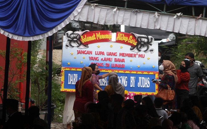 Korban dugaan arisan online bodong membawa karangan bunga saat menghadiri resepsi pernikahan terduga pelaku penipuan arisan online bodong di Serut, Mojosongo, Jebres, Solo, Minggu (12/9/2021). (Solopos/Nicolous Irawan)
