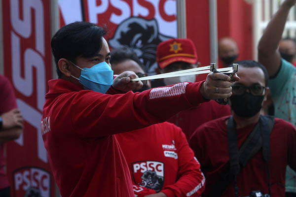 Wali Kota Solo Gibran Rakabuming Raka membidik sasaran untuk memecahkan balon namun gagal pada Peringatan Ke-38 Hari Olahraga Nasional (Haornas) di depan pintu VIP Stadion Manahan, Solo, Kamis (9/9/2021). (Solopos/Nicolous Irawan)