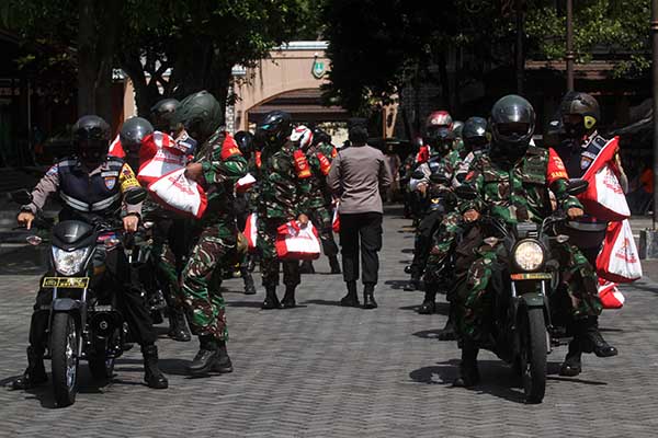 Anggota Bhabinkamtibmas Polresta Solo bersama anggota Babinsa TNI AD bersiap menyerahkan paket sembako dari Akabri 1996. (Solopos/Nicolous Irawan)