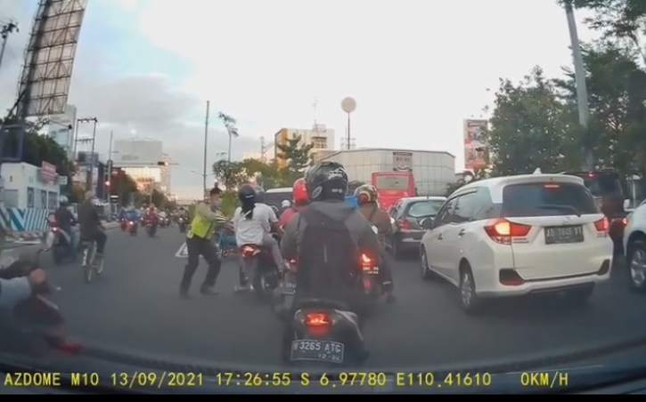 Tangkapan layar video dari unggahan @alvinlie21 di Instagram yang menunjukkan seorang polisi menjatuhkan pengendara sepeda motor di Kota Semarang. (Instagram)