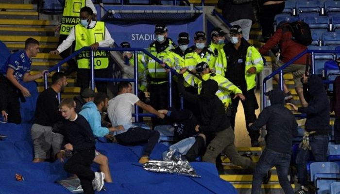 Suporter Leicester (kiri) bentrok dengan suporter Napoli setelah peluit akhir dibunyikan pada pertandingan Grup C Liga Europa di Stadion King Power di Leicester, Inggris, Jumat (17/9/2021) dini hari WIB. (Oli SCARFF / AFP)