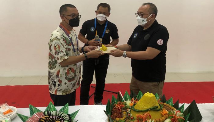 Dirut PT LIB, Akhmad Hadian Lukita (kanan) secara simbolis menyerahkan tumpeng kepada Ketua LOC pertandingan pembuka Liga 2, Ginda Ferachtriawan, setelah doa bersama pembukaan Liga 2 di Stadion Manahan Solo, Sabtu (25/9/2021) sore. (Solopos.com/Ichsan Kholif Rahman)