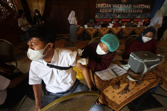 Siswa menahan sakit saat disuntik vaksin oleh petugas medis pada vaksinasi Covid-19 di Graha Saba Buana, Sumber, Banjarsari, Solo, Rabu (22/9/2021). (Solopos/Nicolous Irawan)