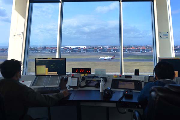 Petugas memantau dan mengatur pergerakan pesawat udara di menara Air Traffic Controller (ATC) Bandara Internasional I Gusti Ngurah Rai, Bali, Rabu (13/10/2021). AirNav Indonesia menyiapkan berbagai fasilitas, sarana prasarana, prosedur serta menyiagakan sekitar 80 orang petugas ATC untuk pelayanan navigasi pesawat udara di Bandara Ngurah Rai guna menyambut pembukaan kembali penerbangan internasional di bandara tersebut. ANTARA FOTO/Fikri Yusuf/rwa.