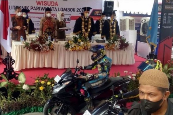 Wisudawan mengenakan kostum balap saat mengikuti wisuda di Poltekpar Lombok. (Foto: (Suara.com)