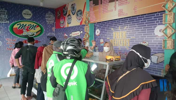 Warga mendatangi toko MM Bakery di Jl. DI Panjaitan, Kota Madiun, untuk mengambil roti gratis dalam rangka menyambut Maulid Nabi Muhammad SAW, Senin (18/10/2021). (Madiunpos.com/Abdul Jalil)