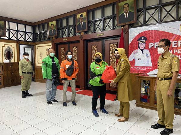 Bupati Sukoharjo, Etik Suryani, menyerahkan bantuan kepada driver ojek online (ojol) di Lobby Kantor Bupati Sukoharjo Senin (25/10/2021). (Solopos/Candra Putra Mantovani)