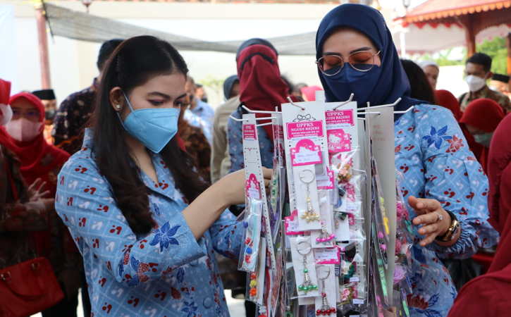 Ketua Tim Penggerak PKK Kota Solo, Selvi Ananda (kiri) beserta wakil, Serly Teguh Prakosa mengamati produk gantungan kunci bikinan warga dalam pencanangan Kampung KB Karta Raharja Kadipiro di Kelurahan Kadipiro, Banjarsari, Jumat (22/10/2021). (Chrisna Canis Cara/Solopos)