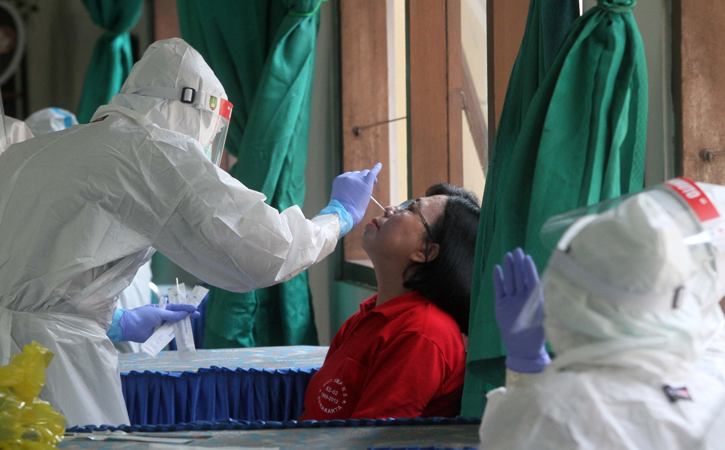 Petugas medis mengambil sampel lendir milik guru saat tes usap PCR di SMP Negeri 8, Solo, Jumat (22/10/2021). (Solopos-Nicolous Irawan)