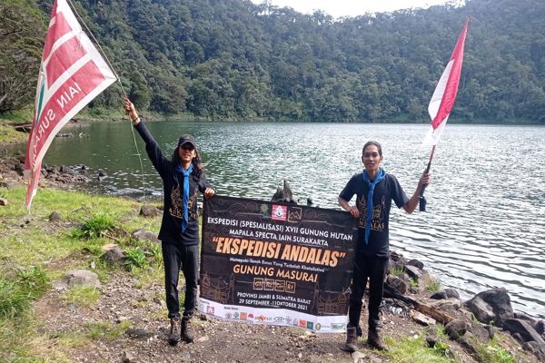 Dua anggota Mapala Specta UIN RM Said Surakarta mengibarkan bendera di gunung hutan Masurai Sumatra, 11 Oktober 2021. (Istimewa/Specta)