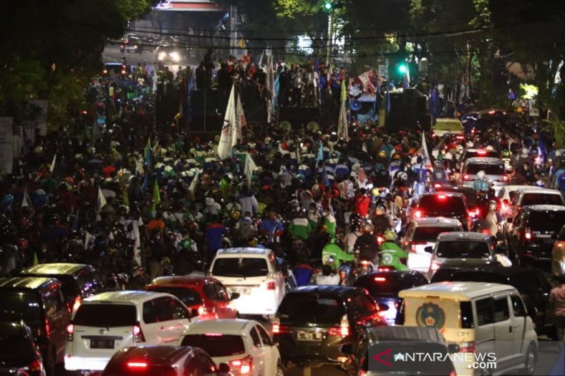 Massa aksi saat meninggalkan Gedung Negara Grahadi di Surabaya, Selasa (30/11/2021) malam, seusai menyepakati keputusan sementara terkait persoalan UMK 2022. (Antara)