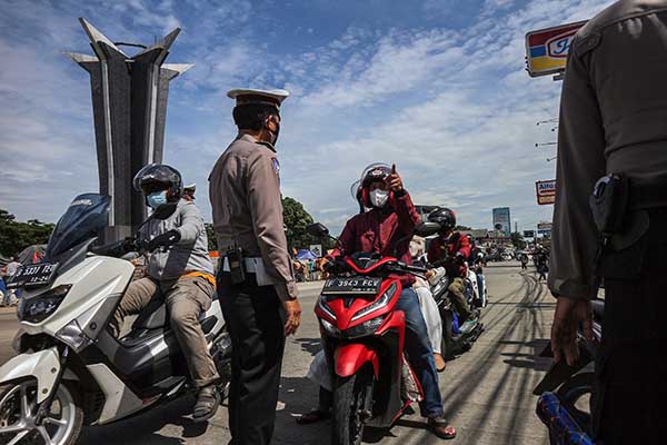 Polisi menghentikan pengendara sepeda motor dengan plat nomor ganjil saat penerapan sistem ganjil genap dalam Pemberlakuan Pembatasan Kegiatan Masyarakat (PPKM) level 3 di kawasan wisata Sentul, Kabupaten Bogor, Jawa Barat, Minggu (28/11/2021). (Antara/Yulius Satria Wijaya)