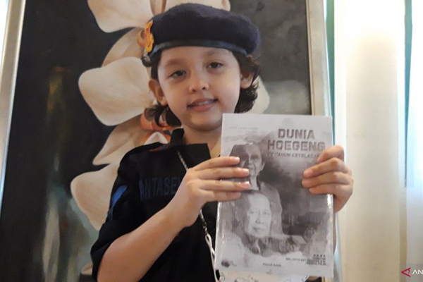 Salah seorang cicit dari mantan Kapolri Jenderal Polisi Drs. Hoegeng Imam Santoso memegang buku berjudul "Dunia Hoegeng, 100 Tahun Keteladanan" dalam rangka 100 tahun Pak Hoegeng yang ditulis oleh wartawan senior Farouk Arnaz di Jakarta, Minggu. (ANTARA/Muhammad Zulfikar)