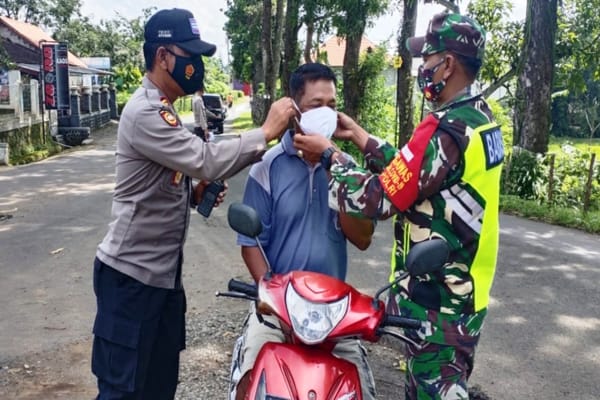 Aparat Polsek dan Koramil Pracimantoro meminta warga memakai masker saat operasi yustisi penegakan disiplin protokol kesehatan di tepi jalan dekat gerbang Tempat Wisata Museum Karst Indonesia di Kecamatan Pracimantoro, Kabupaten Wonogiri, Rabu (17/11/2021). (Istimewa/Polres Wonogiri)