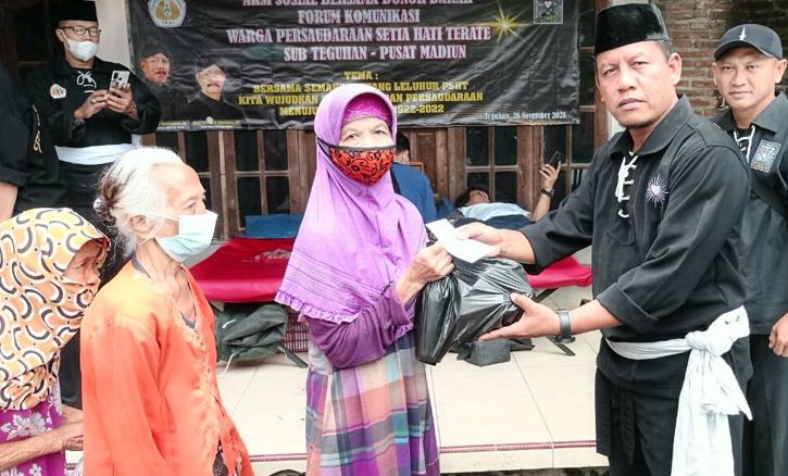 Ketua Forum Komunikasi PSHT Teguhan, Sragen Wetan, Sragen, Gianto (kanan) menyerahkan bantuan sembako kepada warga Teguhan, Sragen, Minggu (28/11/2021). (Istimewa/PSHT Teguhan)
