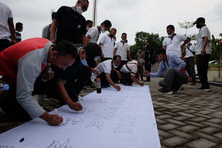 Anggota Persatuan Perangkat Desa (Praja) Kecamatan Tanon memberikan tanda tangan sebagai sikap atas penolakan terhadap Peraturan Bupati (Perbub) No.76/2017 tentang Pengelolaan Aset Desa di halaman Kantor Kecamatan Tanon, Sragen, Jumat (3/12/2021). (Solopos.com/Wahyu Prakoso)