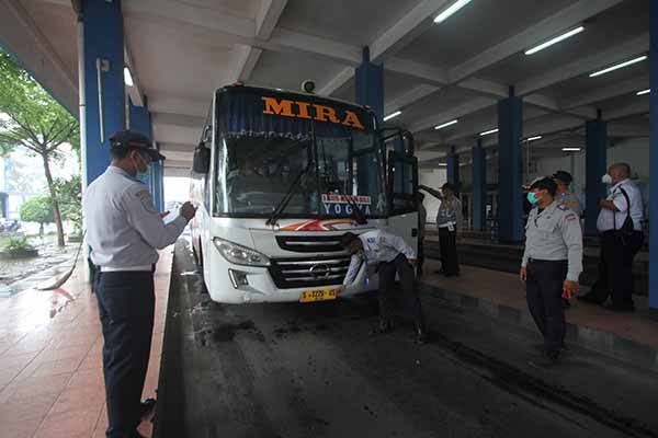 Petugas dari Dirjen Perhubungan Darat Kementerian Perhubungan (Kemenhub) bersama Dinas Perhubungan (Dishub) Kota Solo menguji kelaikan armada bus antarkota antarprovinsi (AKAP) di Terminal Tirtonadi, Solo, Selasa (21/12/2021). (Solopos/Nicolous Irawan)