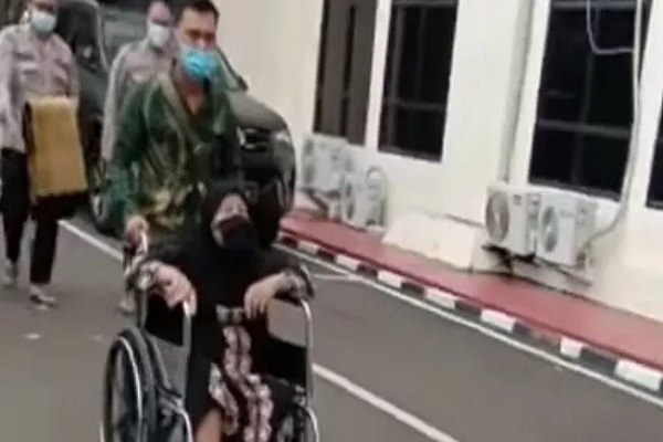 Rodiah, wanita tua asal Kampung Gudang Huut, Desa Sindangmulya, Kecamatan Cibarusah, Kabupaten Bekasi, Jawa Barat terlihat sedih di kursi rodanya saat datang ke Mapolres Metro Bekasi, Senin (29/11/2021). (Suara.com)