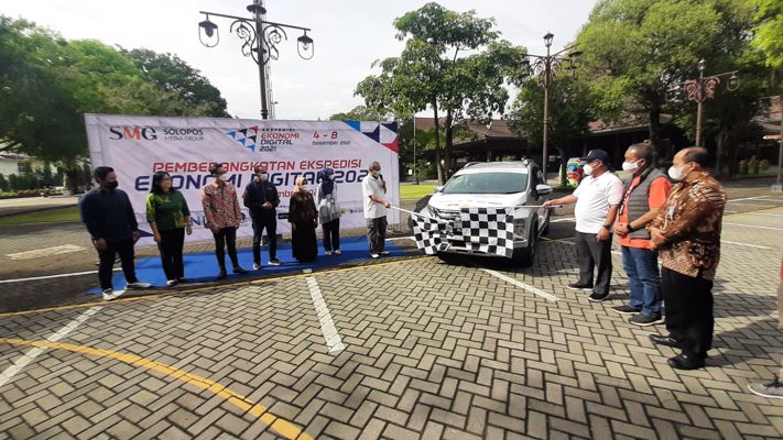 Kepala Kantor Perwakilan Bank Indonesia (BI) Solo, Nugroho Joko Prastowo (pegang bendera start, kanan) dan Sekda Solo, Ahyani (pegang bendera start, kiri) memberangkatkan Tim Ekspedisi Ekonomi Digital 2021 di Balai Kota Solo, Sabtu (4/12/2021) pagi. (Solopos.com-Kurniawan)