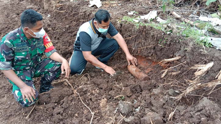 Petugas mengevakuasi temuan proyektil amunisi kaliber 105 mm di lahan Desa Ngrukem, Kecamatan Mlarak, Kabupaten Ponorogo, Jumat (3/12/2021). (Istimewa/Polres Ponorogo)