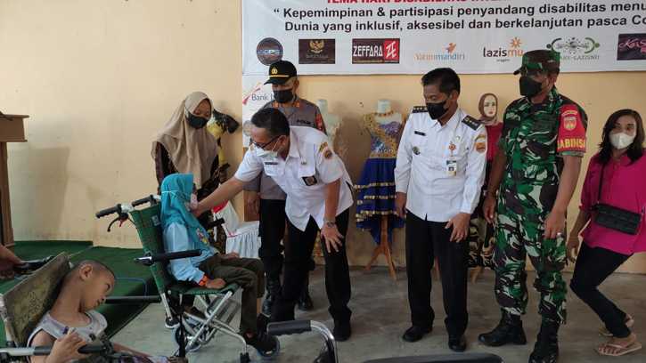 Plt. Kepala Dinsos Sragen, Cosmas Edwi Yunanto, secara simbolis menyerahkan bantuan kursi roda kepada salah seorang penyandang disabilitas di Aula Kecamatan Sambirejo, Sragen, Rabu (8/12/2021). (Istimewa/Yayasan Disabilitas Jaya Abadi)