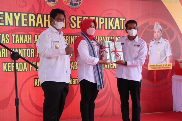 Kepala BPN Klaten, Tentrem Prihatin, menyerahkan sertifikat tanah aset Pemkab kepada Bupati Klaten, Sri Mulyani, di halaman parkir Objek Mata Air Cokro, Rabu (26/1/2022). (Solopos.com/Taufiq Sidik Prakoso)