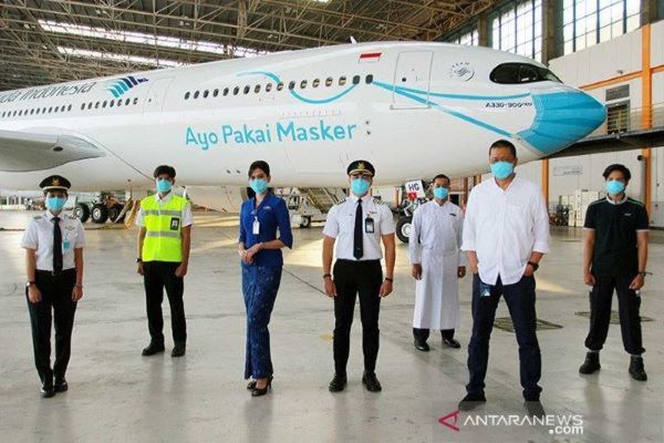Direktur Utama Garuda Indonesia Irfan Setiaputra (kedua dari kanan) berfoto bersama kru seusai meluncurkan pesawat Garuda Indonesia Airbus A330-900 Neo bercorak khusus yang menampilkan visual masker pada bagian moncong pesawat di Hanggar GMF AeroAsia Bandara Soekarno-Hatta, Tangerang, Banten, Kamis 1 November 2020. (Antara/Muhammad Iqbal)