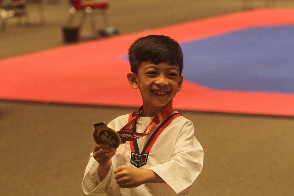 Putra Wali Kota Solo, Gibran Rakabuming Raka, Jan Ethes Srinarendra, tersenyum saat menunjukkan medali seusai memenangi pertandingan beladiri Taekwondo. (Solopos/Nicolous Irawan)