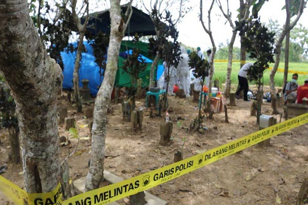 Polisi memasang garis polisi di sekitar lokasi makam siswi SD di Grobogan yang diduga meninggal karena penganiayaan, Senin (17/1/2022). (Solopos.com-Bidhumas Polda Jateng)