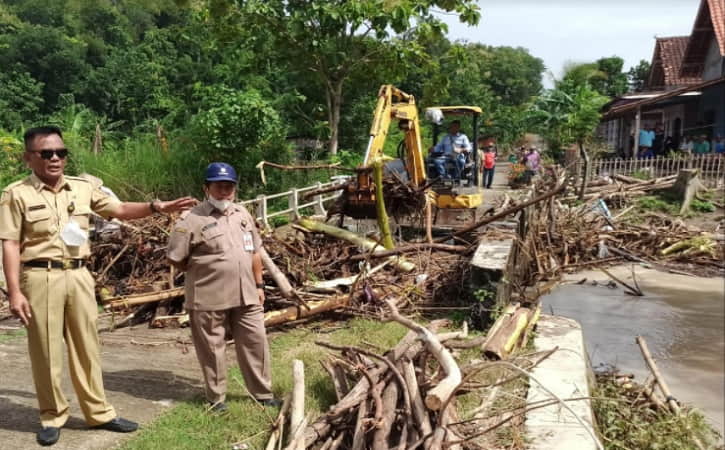 Alat berat dioperasikan untuk mengeruk sampah kayu yang menumpuk di sekitar Jembatan Cendini, Kecamatan Bulu, Sukoharjo, Selasa (18/1/2022). (Istimewa/dok. Bagas Windaryatno)